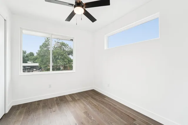 a view of a room with wooden floor and windows