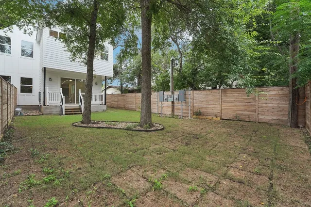 a view of a white house with a large window and large tree