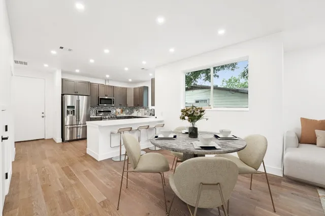 a dining room with furniture and kitchen view