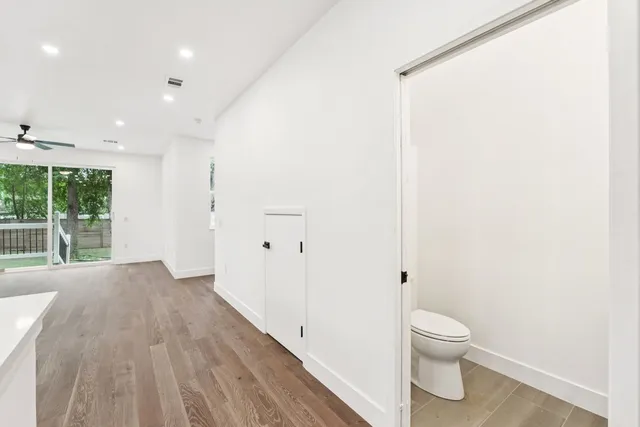 a view of a bedroom with wooden floor and windows