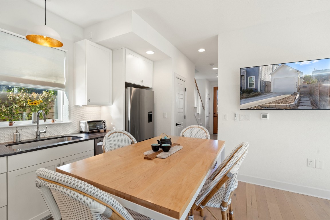 209 Ben Howell Drive, Unit B Austin, TX 78704 - Photo 14 of 39 a kitchen with stainless steel appliances a sink a stove a refrigerator a dining table and chairs with wooden floor