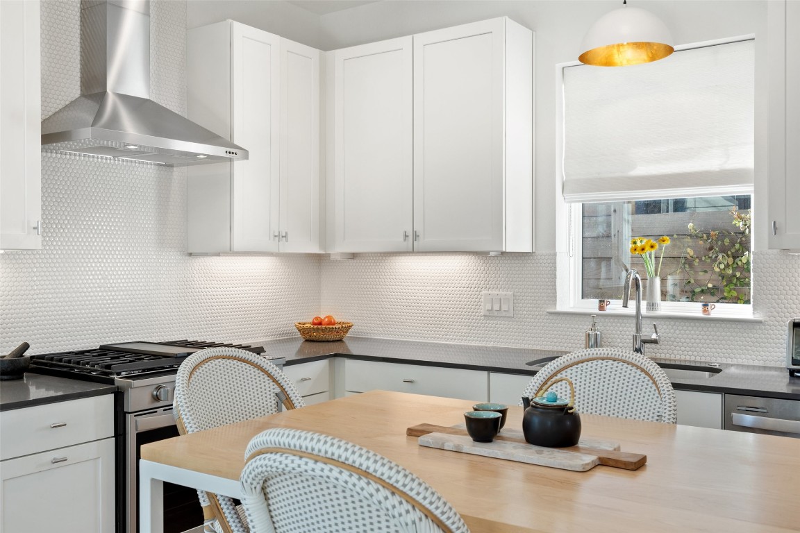 209 Ben Howell Drive, Unit B Austin, TX 78704 - Photo 22 of 39 a kitchen with stainless steel appliances granite countertop a stove a sink a refrigerator and white cabinets with wooden floor