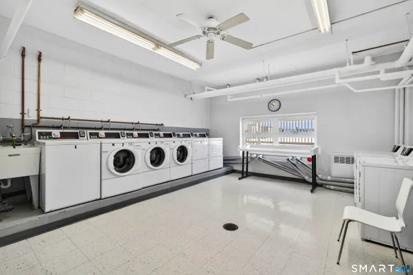 a utility room with stainless steel appliances cabinets and wooden floor