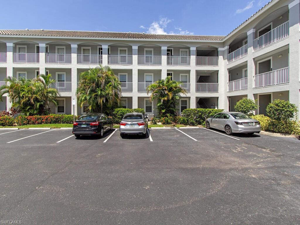 519 Roma Court, Unit 3201 Naples, FL 34110 - Photo 13 of 17 a building with cars parked in front of a building