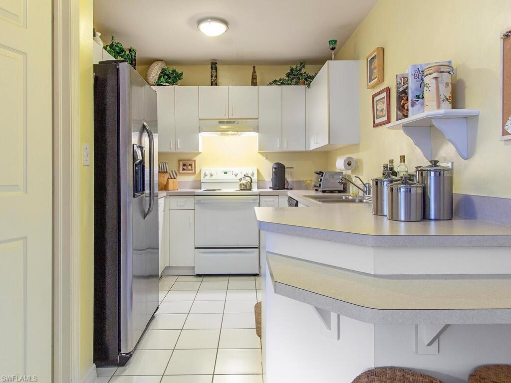 519 Roma Court, Unit 3201 Naples, FL 34110 - Photo 5 of 17 a kitchen with a sink appliances and cabinets