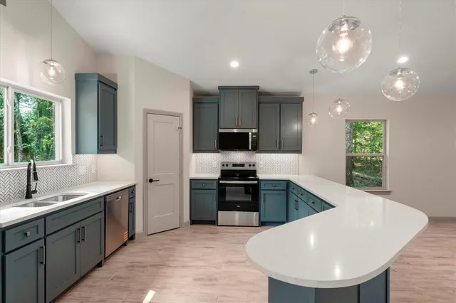 a large kitchen with kitchen island a sink stainless steel appliances and cabinets