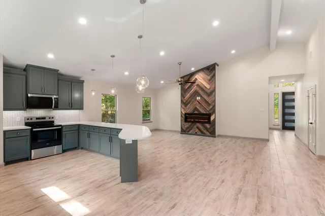 a large room with kitchen island a sink wooden floor and a window