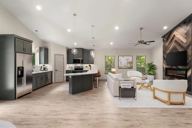 a living room with stainless steel appliances furniture flat screen tv and view