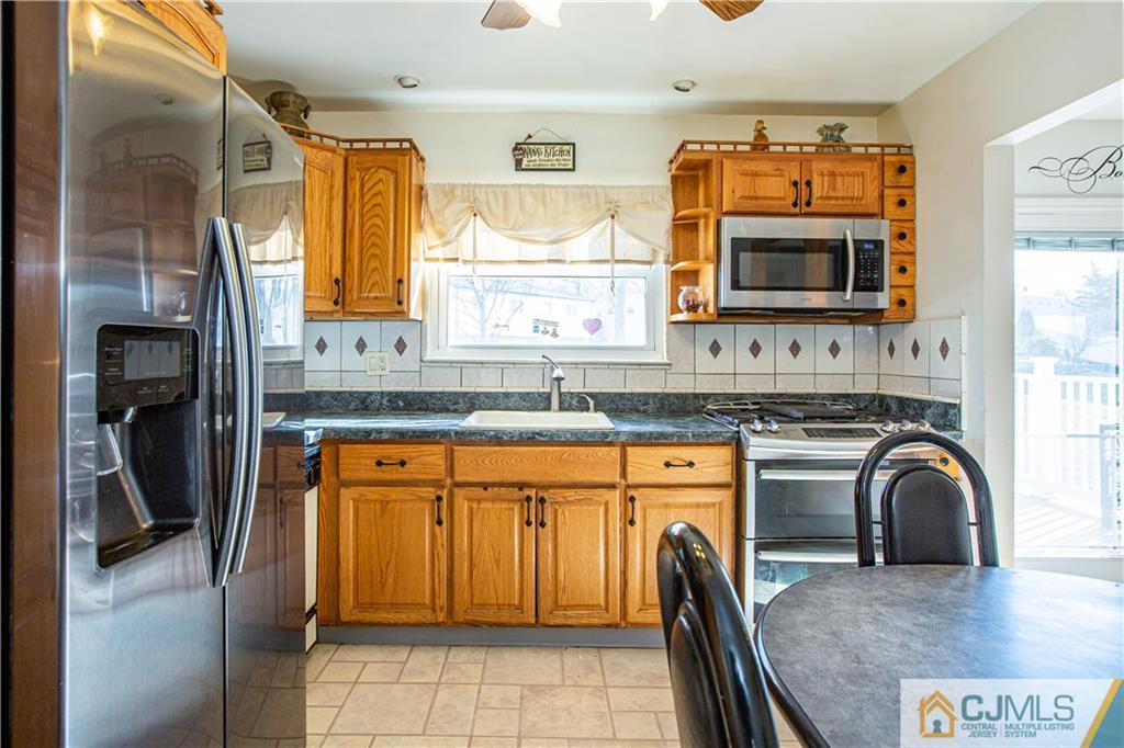 7 Fulton Road Somerset, NJ 08873 - Photo 6 of 24 a kitchen with stainless steel appliances granite countertop a stove top oven a sink a dining table and chairs