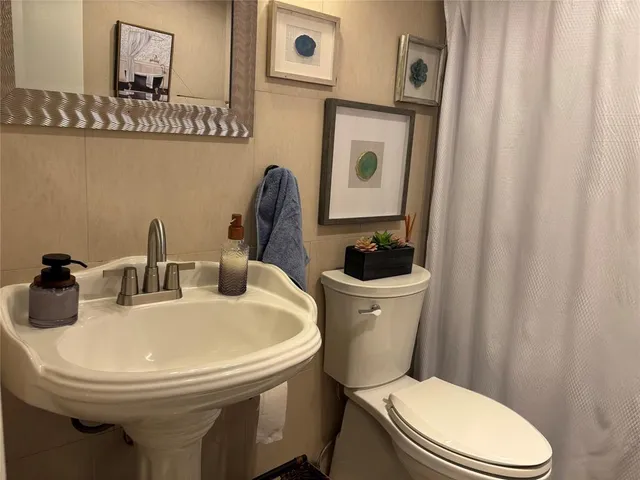 a bathroom with a toilet a sink and a mirror