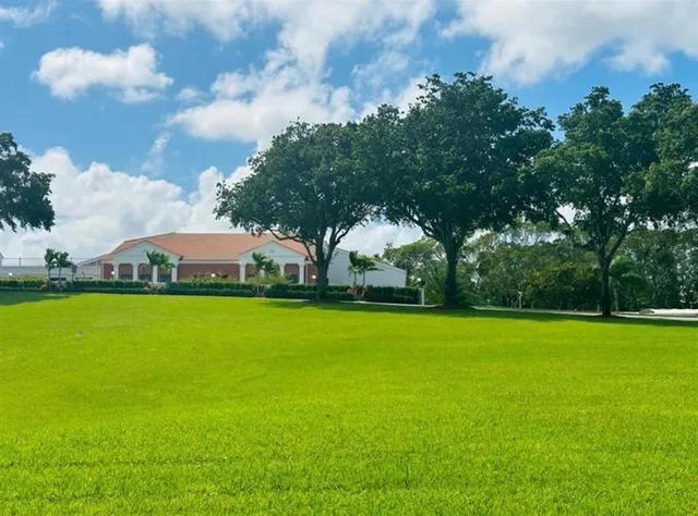 a view of a fountain in front of a house with a big yard