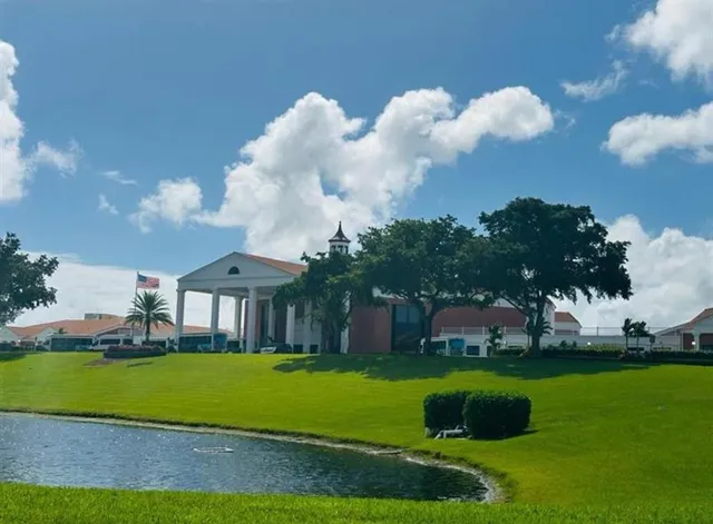 a view of a house with a big yard and a fountain