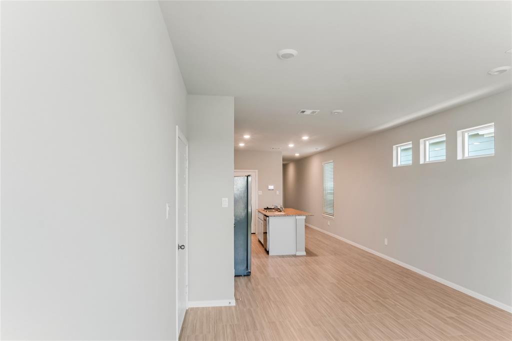 3116 Pecan Farm Lane Fort Worth, TX 76140 - Photo 12 of 25 a view of a room with wooden floor and a ceiling fan