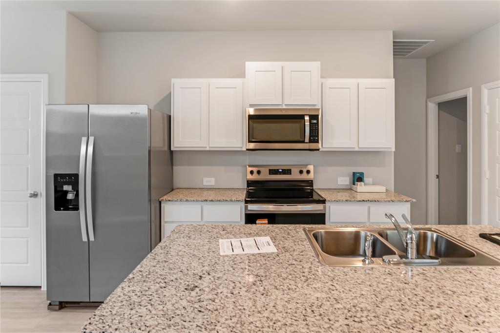 3116 Pecan Farm Lane Fort Worth, TX 76140 - Photo 4 of 25 a kitchen with kitchen island a sink stove and refrigerator