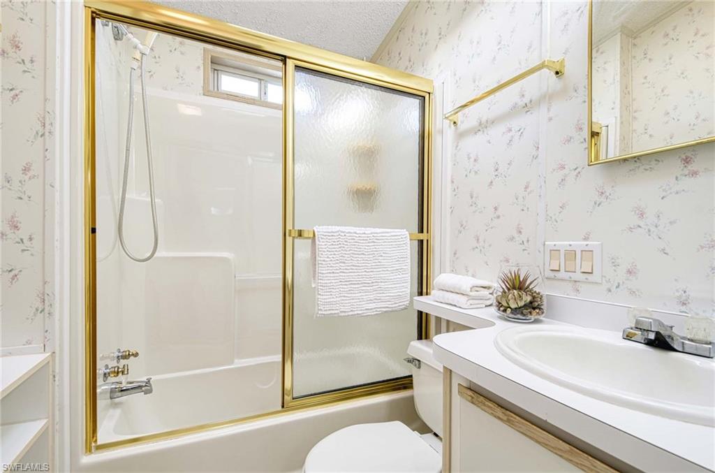 21 Onyx Drive, Unit 21O Naples, FL 34114 - Photo 11 of 30 Full bathroom with vanity, toilet, enclosed tub / shower combo, and a textured ceiling