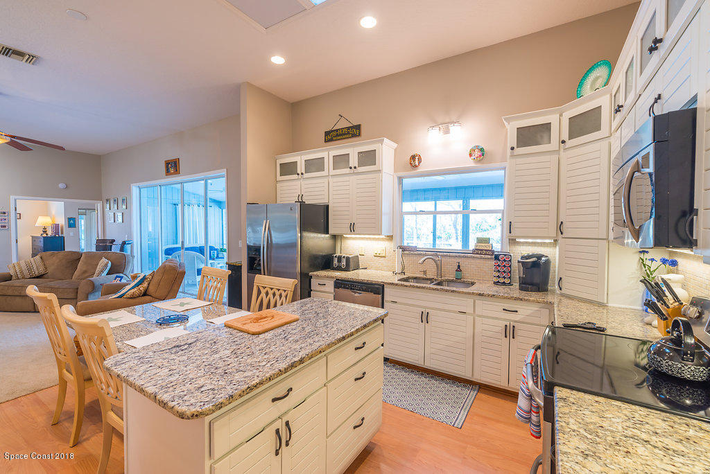 3956 Sparrow Hawk Road Melbourne, FL 32934 - Photo 13 of 34 a kitchen with stainless steel appliances granite countertop a sink dishwasher stove refrigerator and cabinets