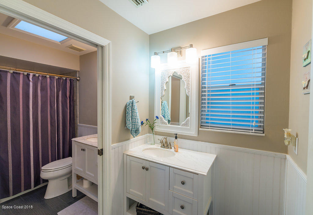 3956 Sparrow Hawk Road Melbourne, FL 32934 - Photo 24 of 34 a bathroom with a sink a toilet and a mirror