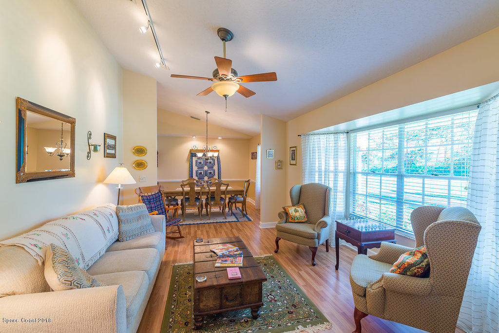 3956 Sparrow Hawk Road Melbourne, FL 32934 - Photo 7 of 34 a living room with furniture a flat screen tv and a large window