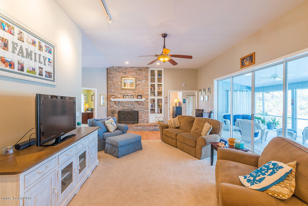 3956 Sparrow Hawk Road Melbourne, FL 32934 - Photo 9 of 34 a living room with furniture a flat screen tv and a fireplace