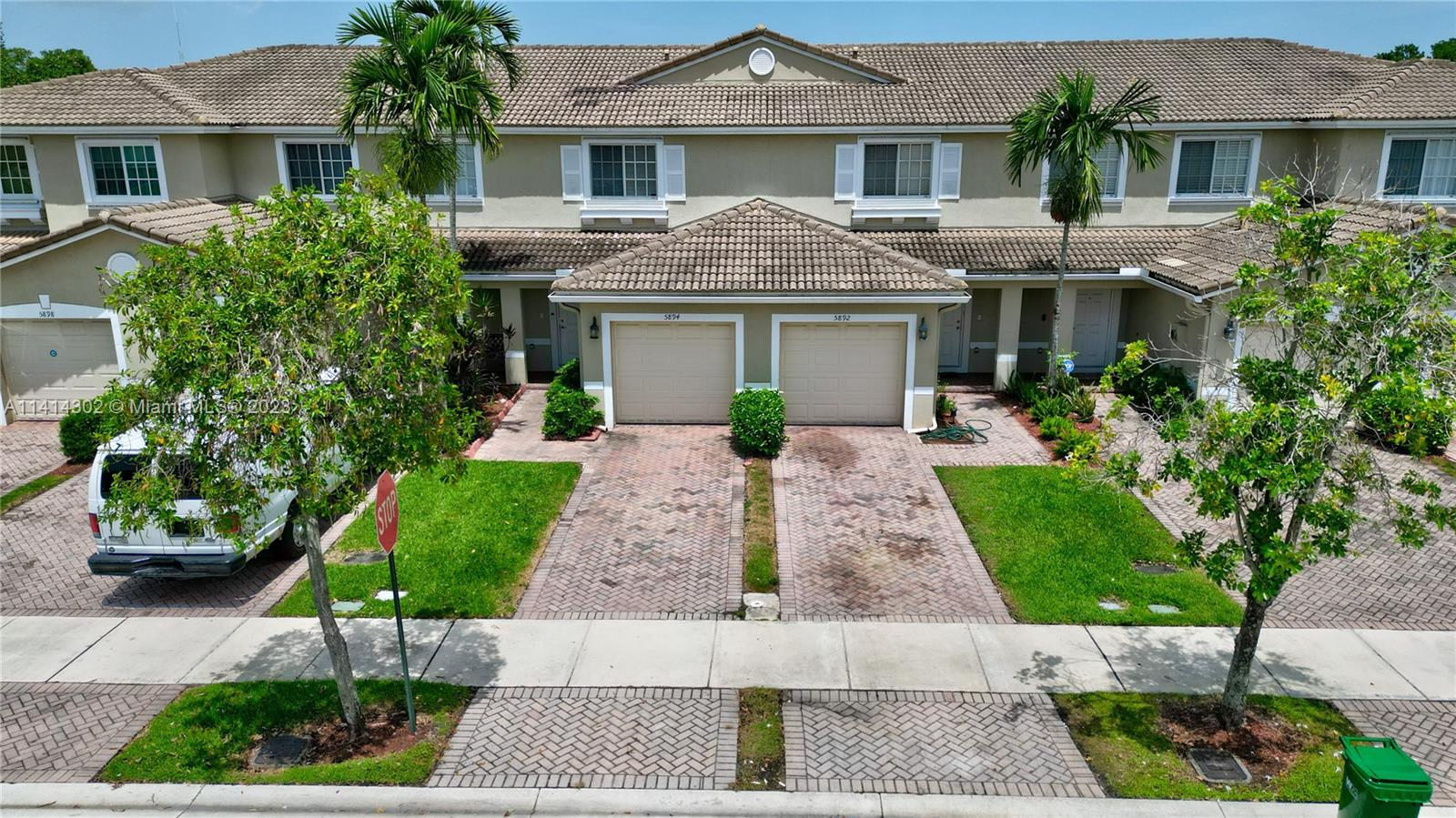 a front view of a house with a yard and potted plants