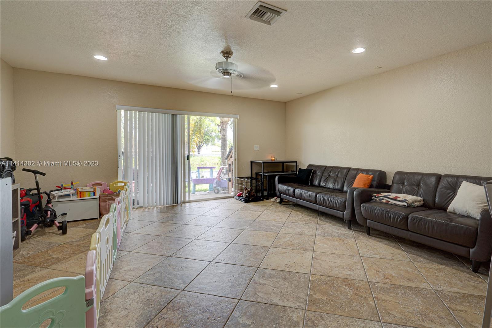 5894 Abbey Road Tamarac, FL 33321 - Photo 11 of 48 a living room with furniture and a flat screen tv