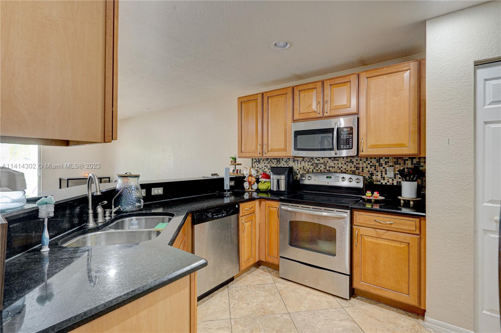 5894 Abbey Road Tamarac, FL 33321 - Photo 17 of 48 a kitchen with stainless steel appliances granite countertop a stove a sink and a microwave