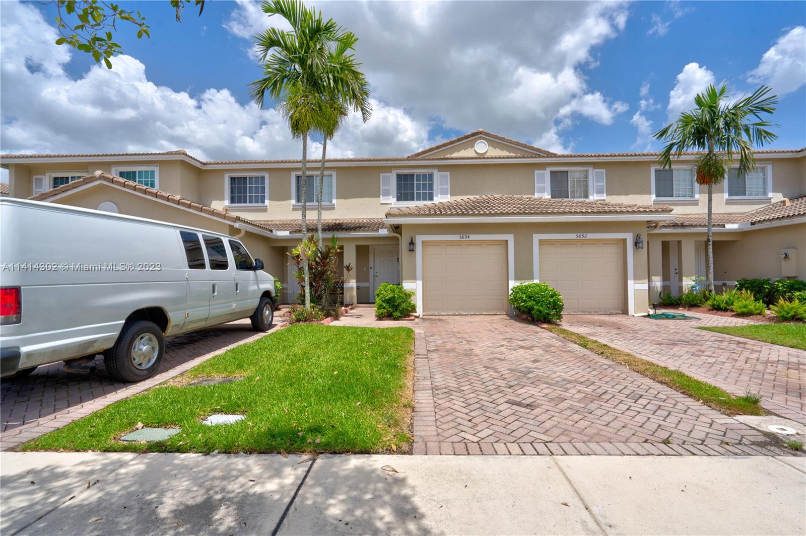 5894 Abbey Road Tamarac, FL 33321 - Photo 2 of 48 a front view of a house with a garden and plants