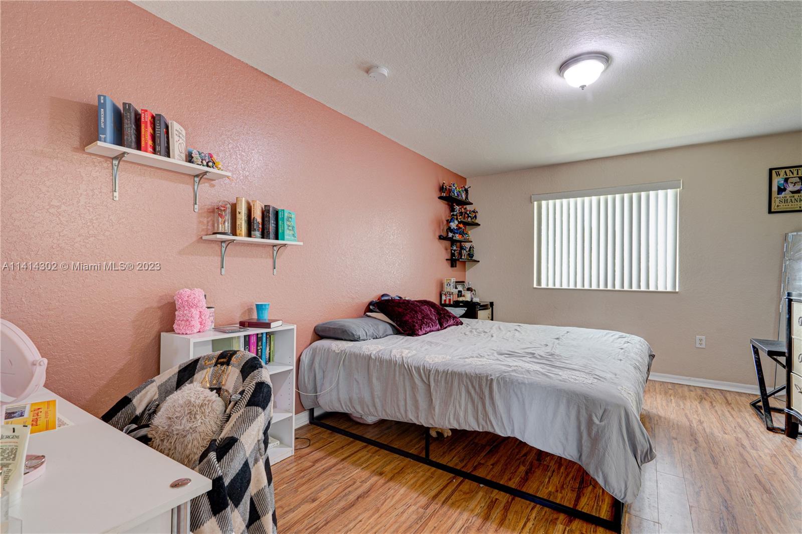 5894 Abbey Road Tamarac, FL 33321 - Photo 27 of 48 a bedroom with a bed and a table in it