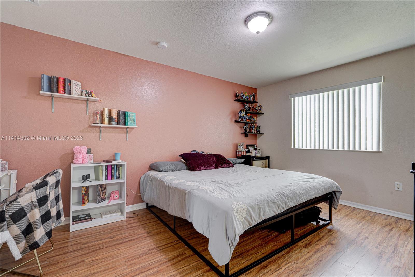 5894 Abbey Road Tamarac, FL 33321 - Photo 28 of 48 a bedroom with a bed and a bookshelf