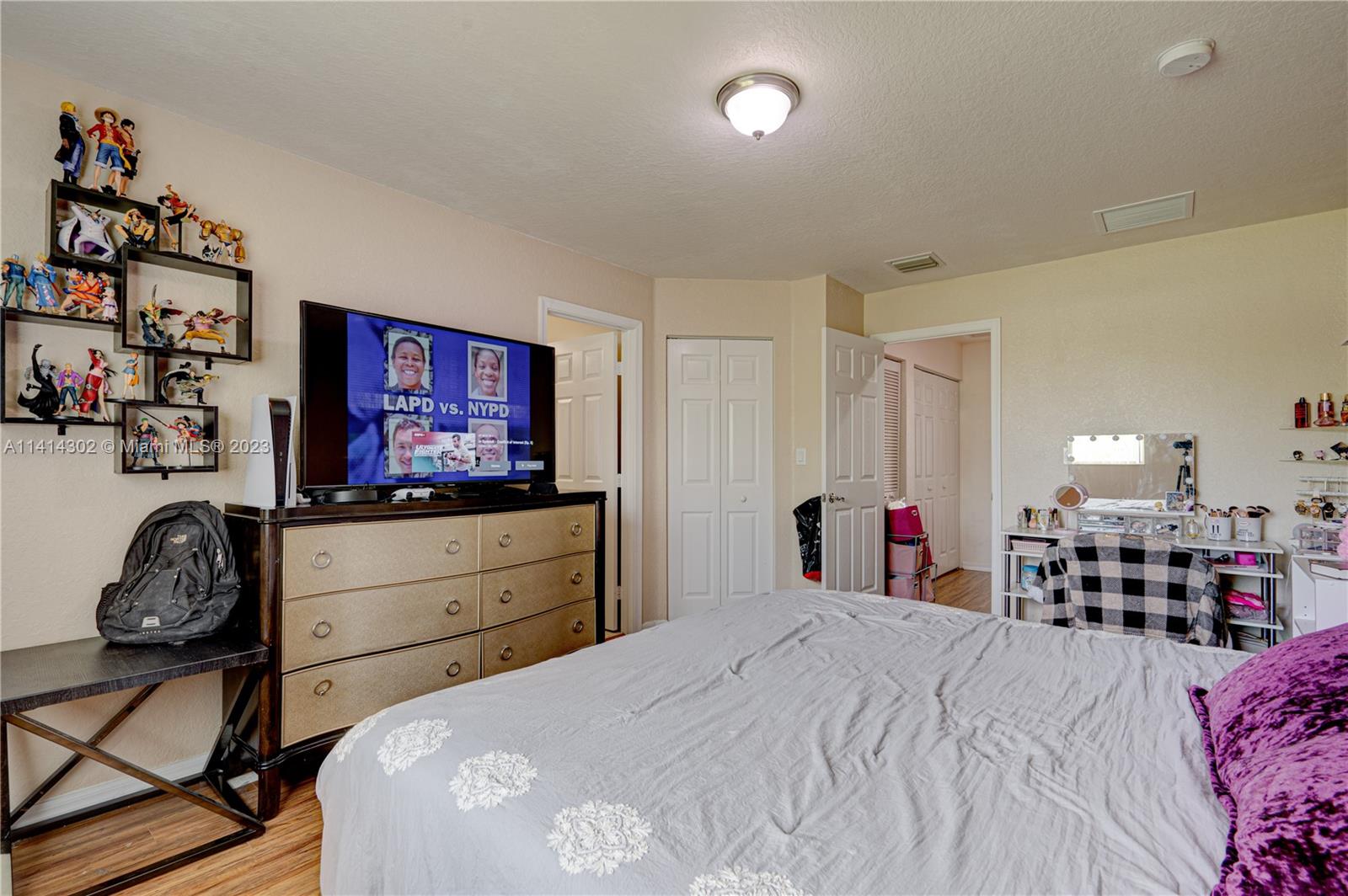 5894 Abbey Road Tamarac, FL 33321 - Photo 31 of 48 a bedroom with a bed and a dresser in it