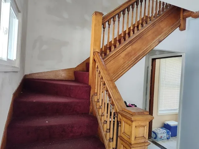 a view of staircase with lots of frames on wall