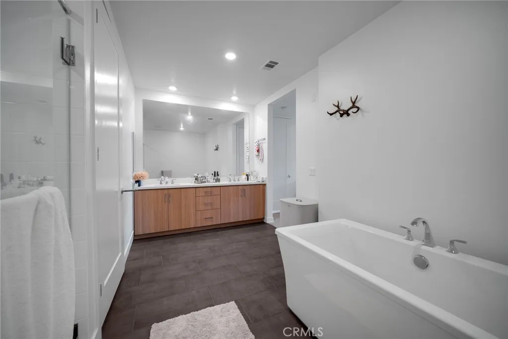 1310 Rivington Irvine, CA 92606 - Photo 14 of 20 a bathroom with a bathtub a mirror a sink and vanity