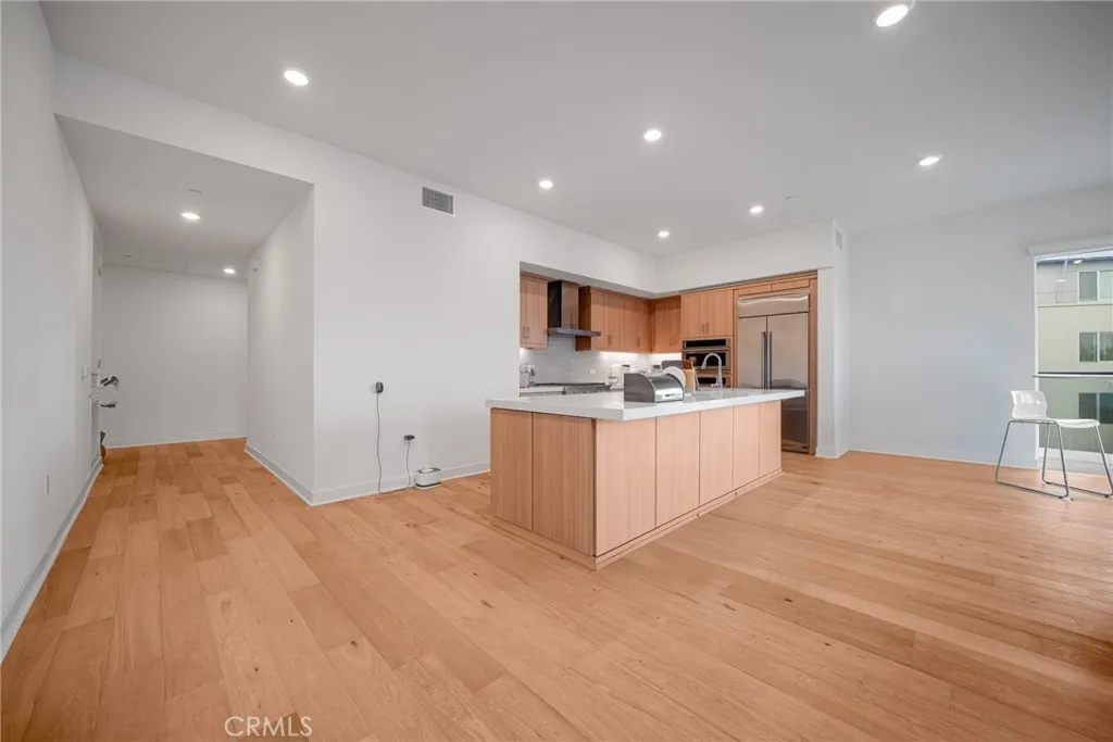 1310 Rivington Irvine, CA 92606 - Photo 7 of 20 a large white kitchen with kitchen island a sink stainless steel appliances and cabinets