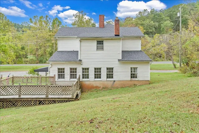 a view of a house with a yard and large tree