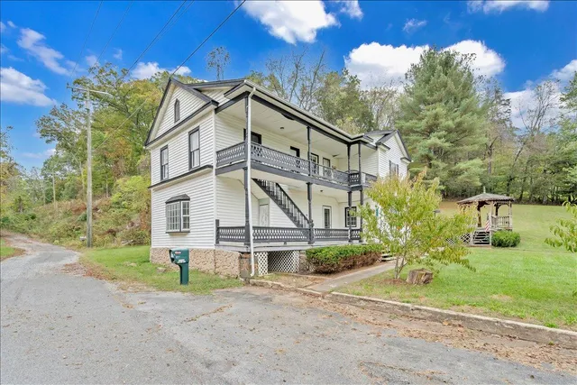 a view of a house with a yard and pathway