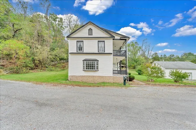 a view of a house with a yard and potted plants
