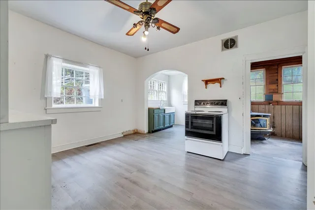 a view of a kitchen with a stove wooden cabinet a kitchen view and wooden floor