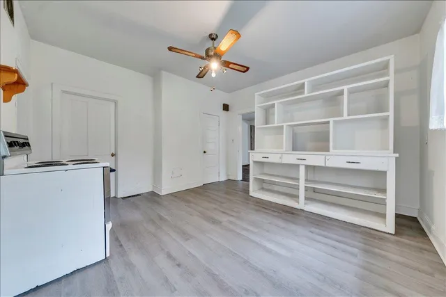 a view of an empty room with a window and wooden floor