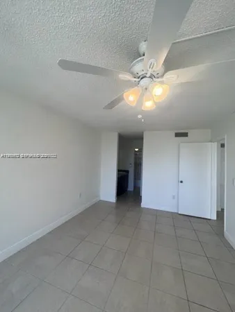 an empty room with a ceiling fan and entryway