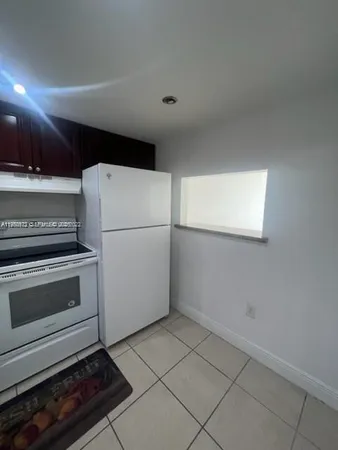 a white refrigerator freezer and a stove sitting inside of a kitchen
