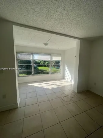 a view of a livingroom with an empty space and a window