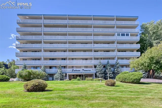 a view of a house with a yard and potted plants