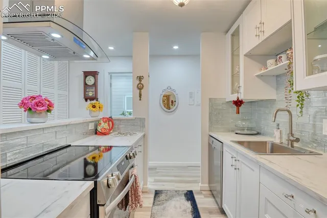 a kitchen with stainless steel appliances granite countertop a sink dishwasher and a stove with wooden floor