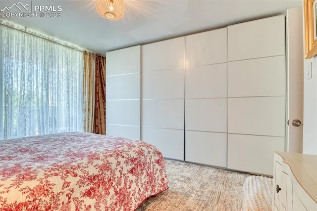 a bedroom with a bed and a chandelier fan