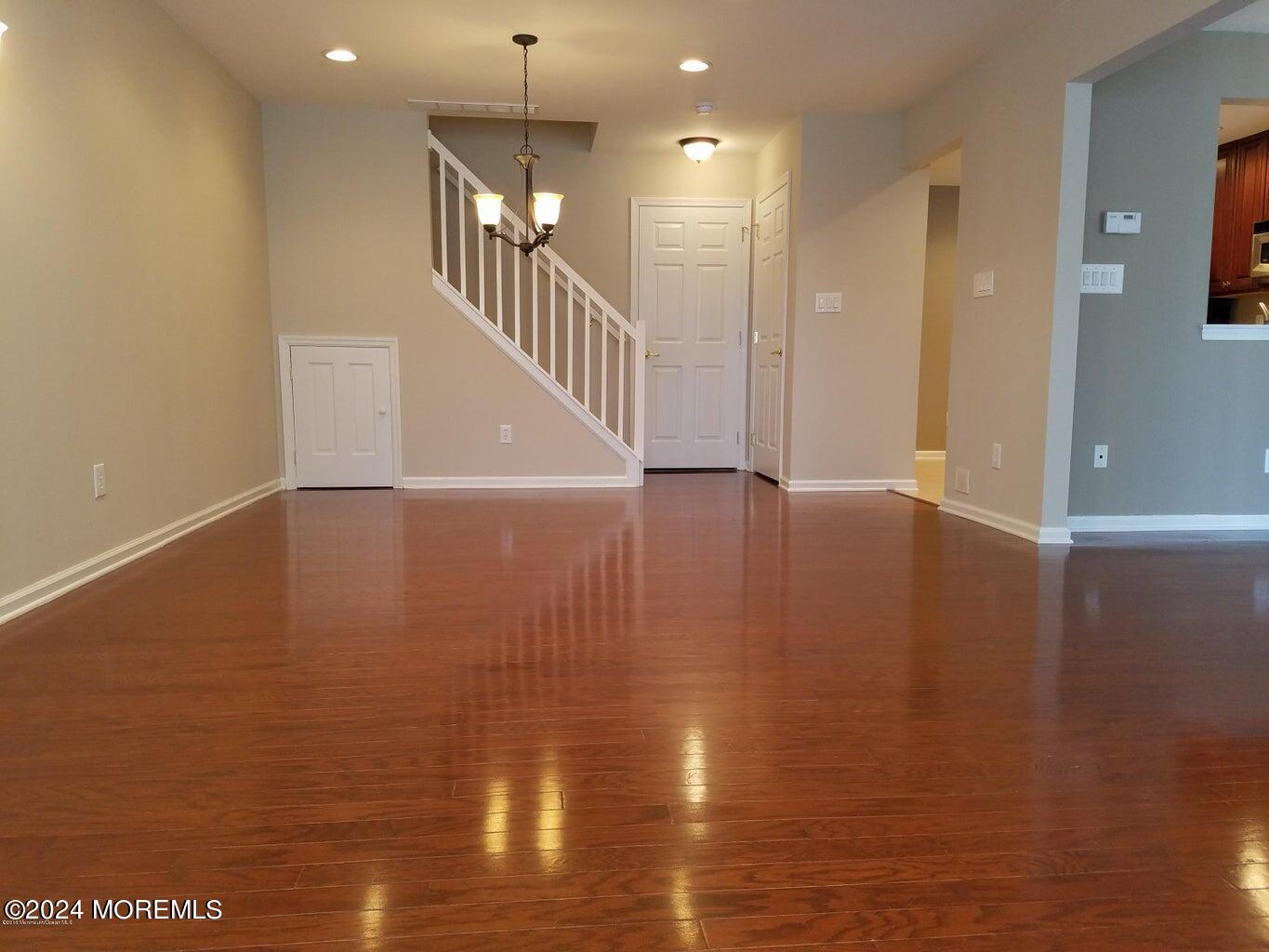 150 Brookfield Drive Jackson, NJ 08527 - Photo 5 of 41 a view of an empty room with wooden floor and a chandelier