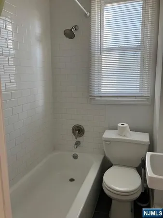 a white toilet sitting next to a bath tub