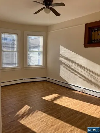 a view of a room with wooden floor and ceiling fan