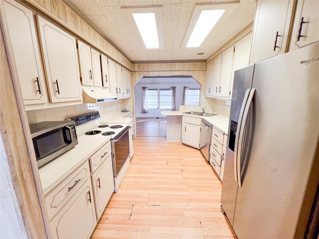 29129 Johnston Road, Unit 2557 Dade City, FL 33523 - Photo 4 of 13 a kitchen with stainless steel appliances a refrigerator a stove a sink and white cabinets