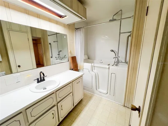 a spacious bathroom with a double vanity sink a mirror and a shower