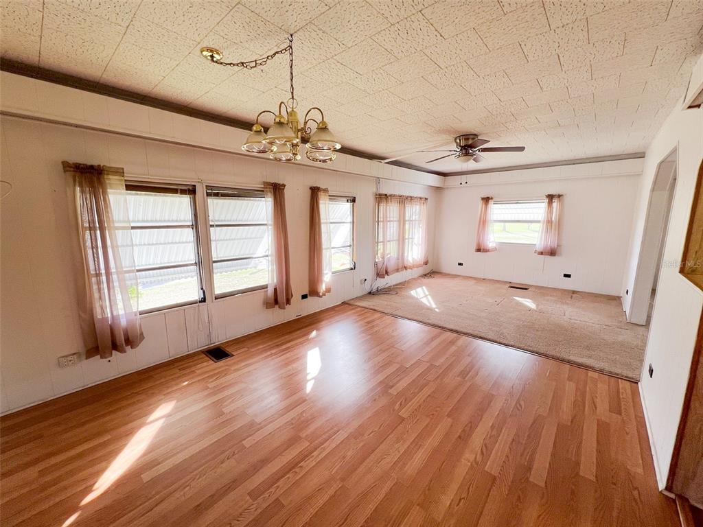 29129 Johnston Road, Unit 2557 Dade City, FL 33523 - Photo 7 of 13 a view of an empty room with wooden floor and a window